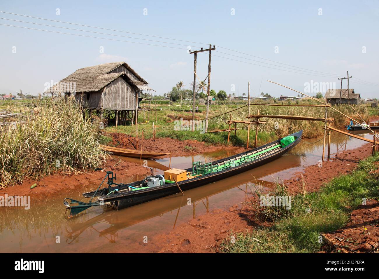 Rural scene at Inle Lake Myanmar - Burma. A long tail boat in one of the canals that leads to Inle Lake. Inle lake is Myanmar's second larget lake and Stock Photo