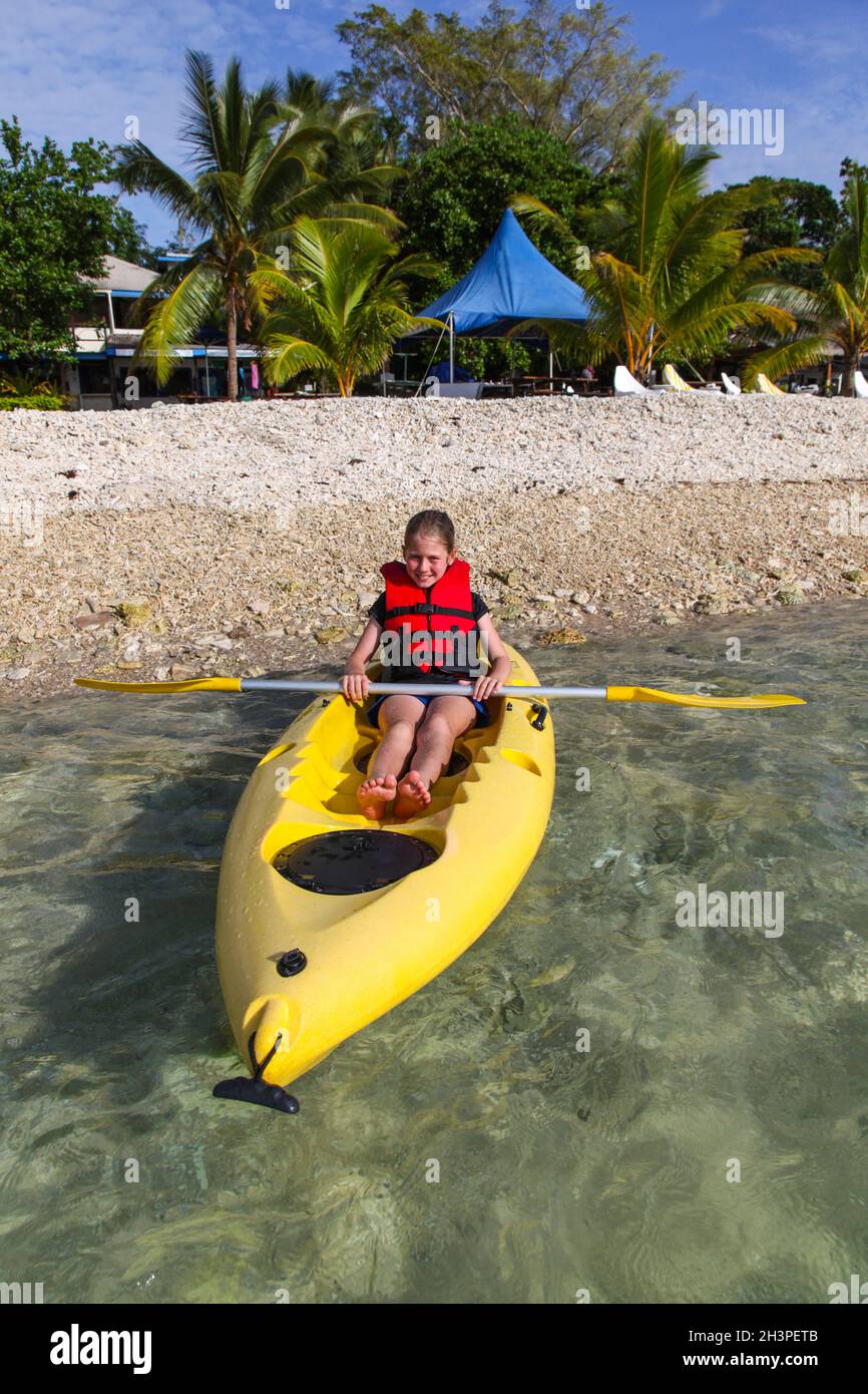 A young girl poses for a photo while kayaking in the tropical island nation of Vanuatu. Stock Photo