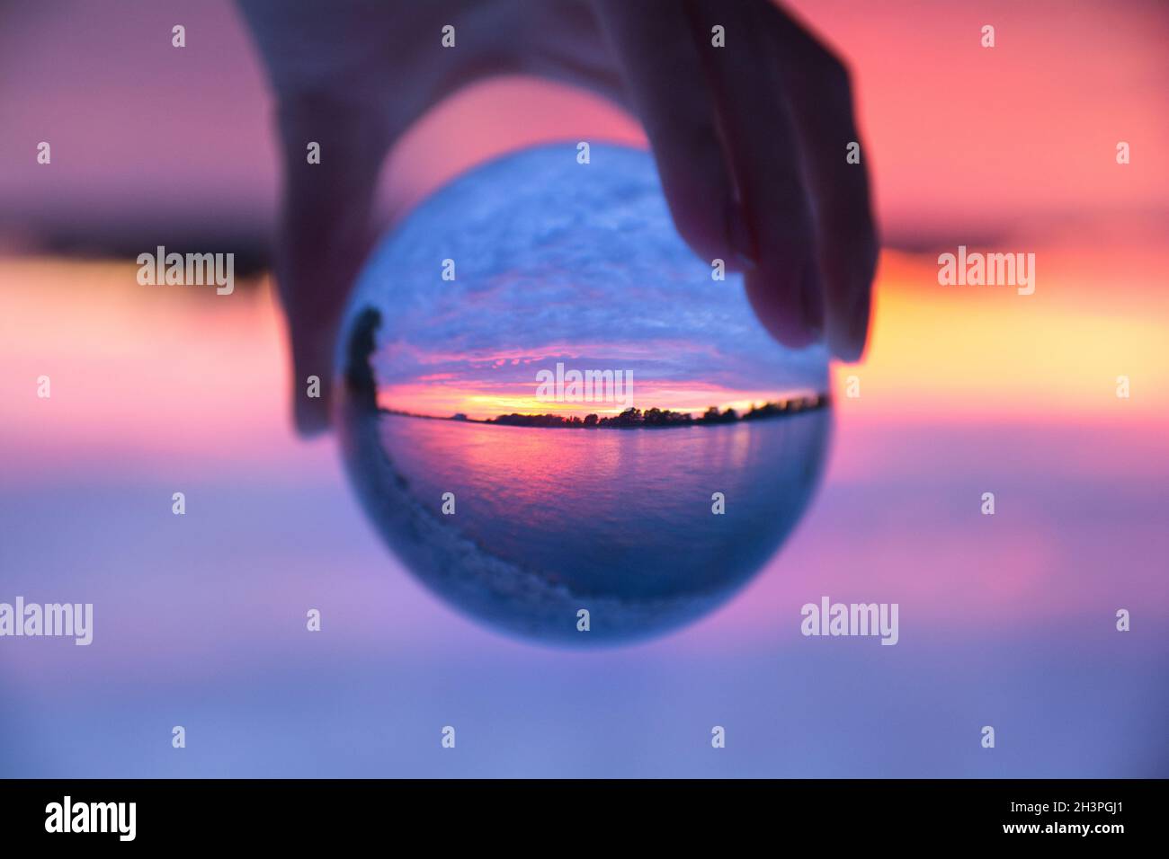 Hand holding a glass ball with reflection of a sunset at Rhine Stock ...