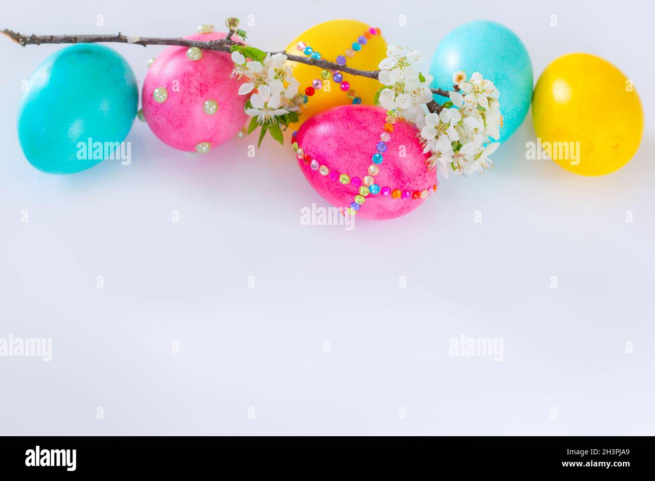 Easter eggs and flower branch on white background Stock Photo