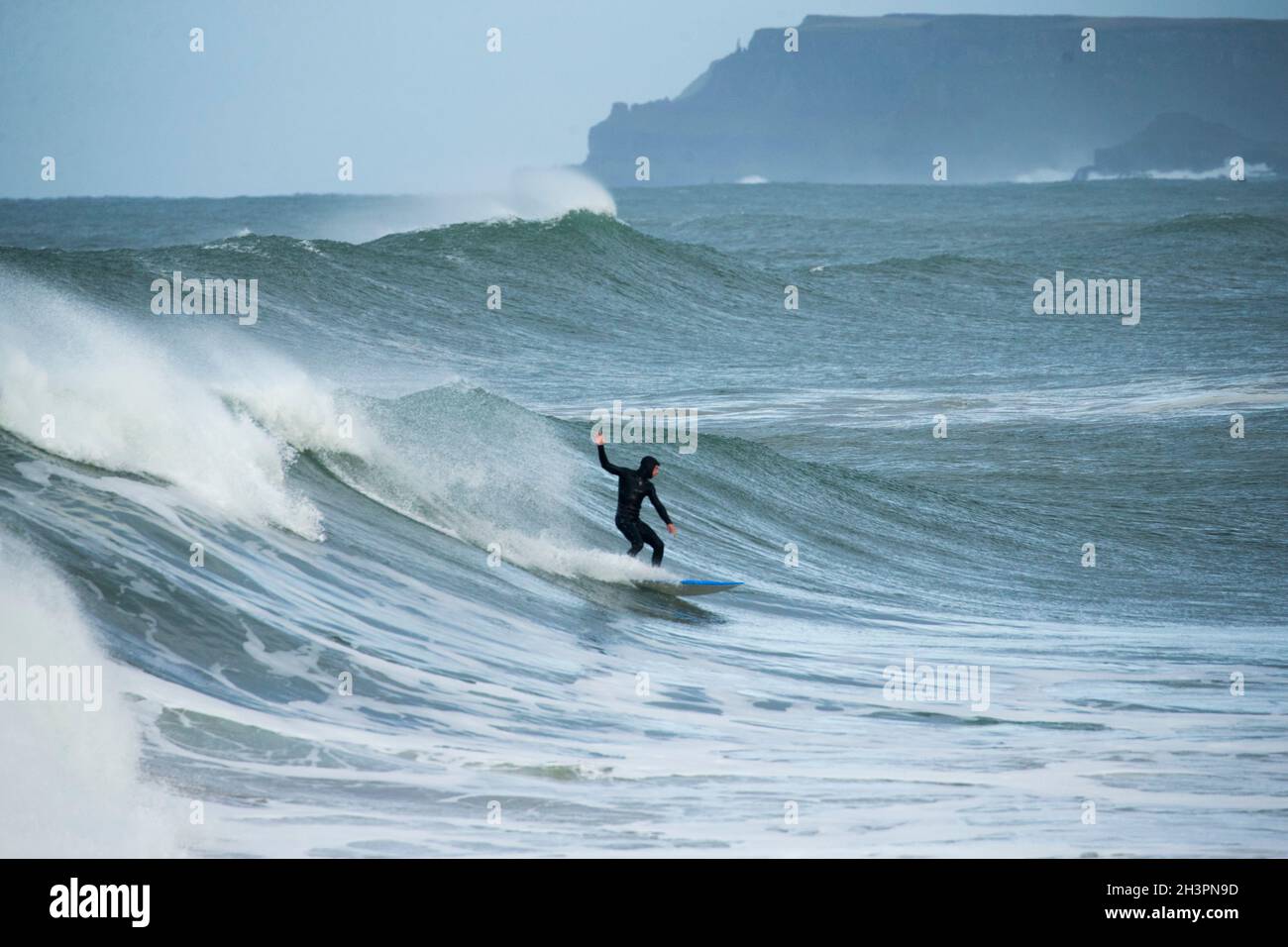 Surfing at Portrush as a big wave storm comes in off the Atlantic Ocean and hits the Antrim Coast, Northern Ireland. Stock Photo