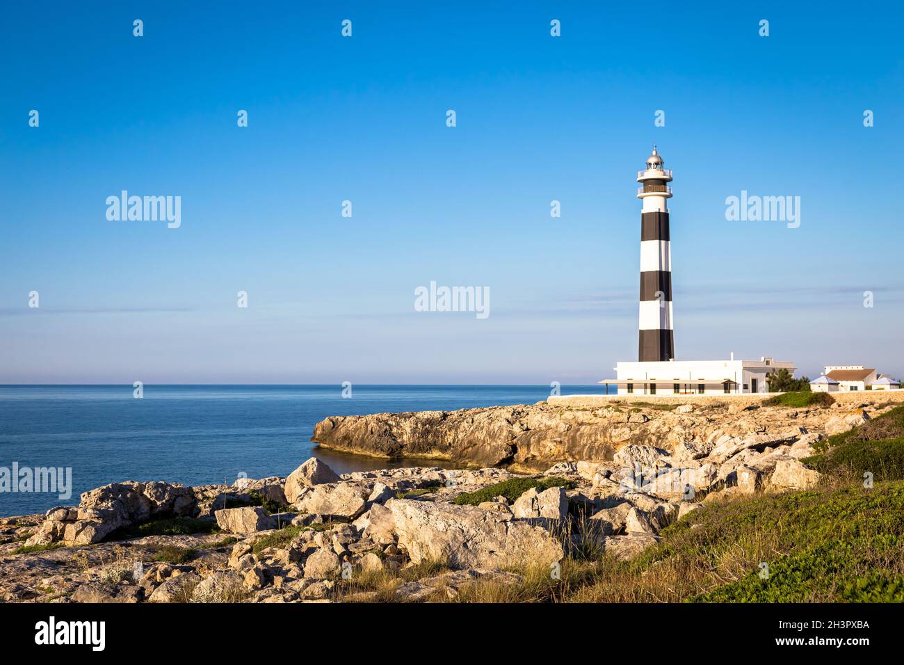 Scenic Artrutx Lighthouse at sunset in Minorca, Spain Stock Photo