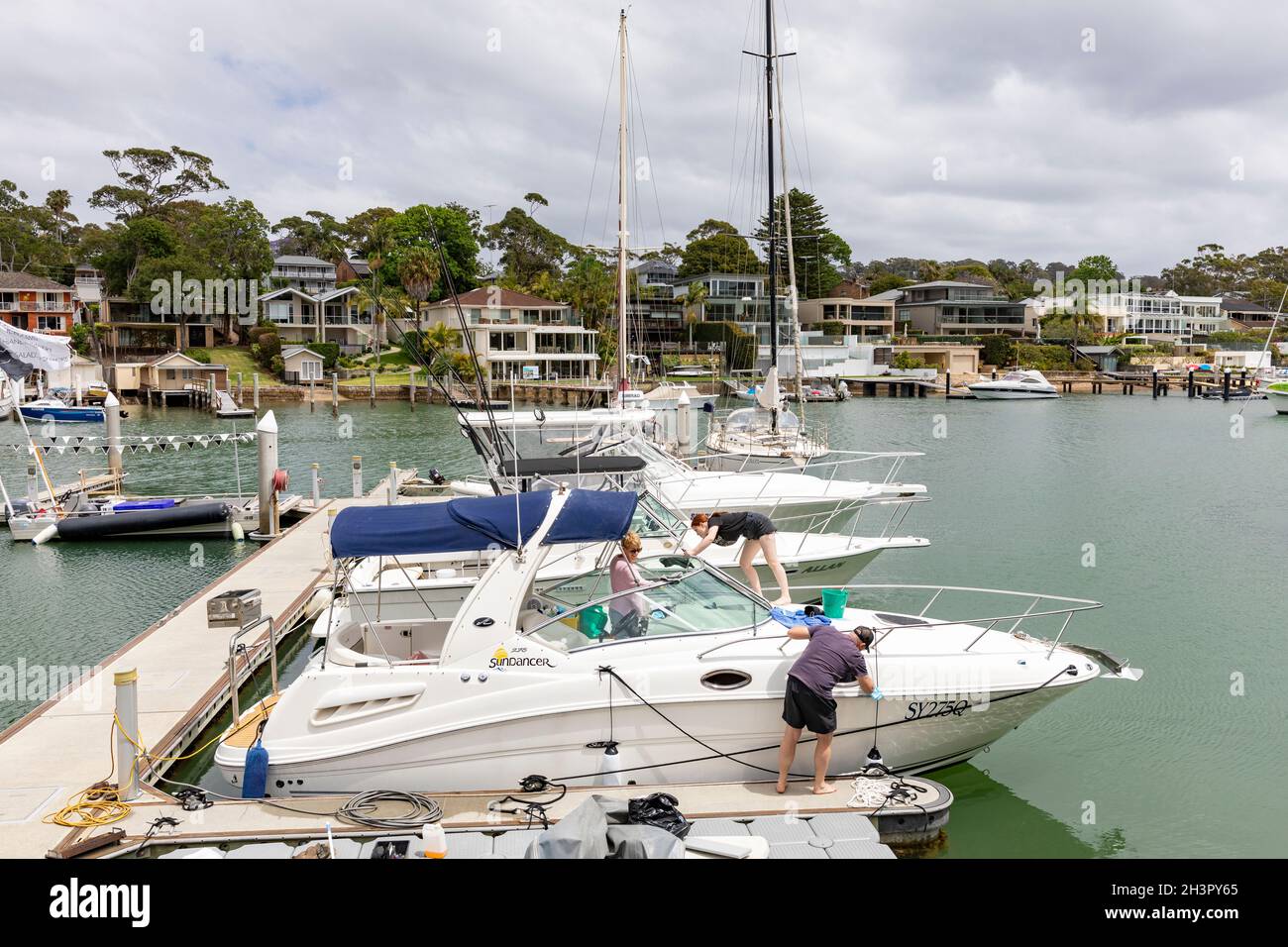 Boat owners cleaning their boat at a marina on Pittwater in Sydney,NSW,Australia Stock Photo