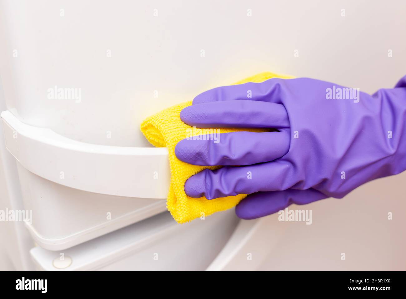 woman's hand wipes the white refrigerator door Stock Photo