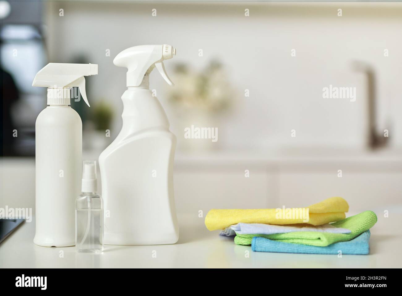 Clean up. Close up shot of detergent bottles and stack of rugs on kitchen surface Stock Photo