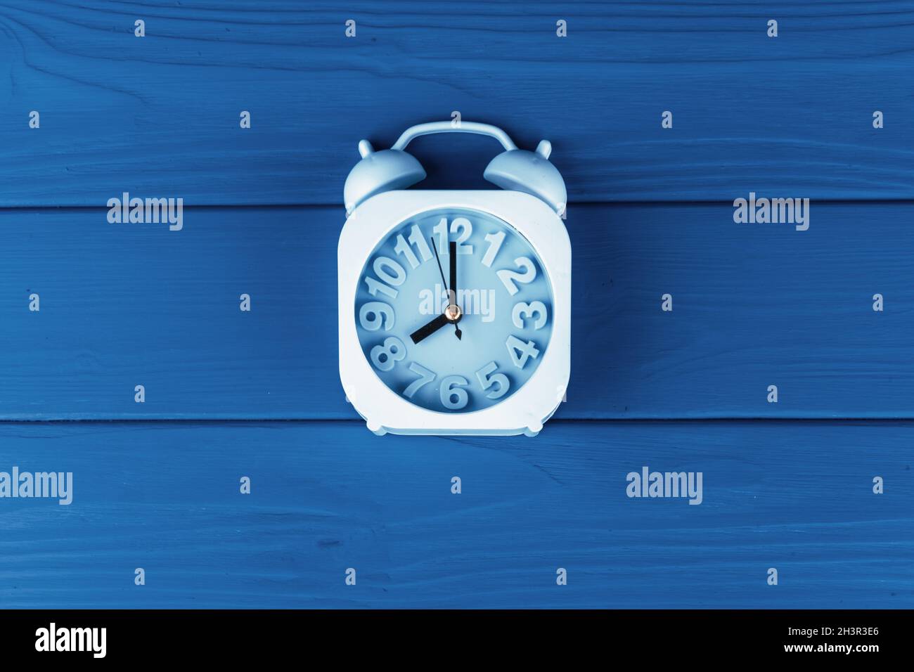 Top view of alarm clock on classic blue background Stock Photo - Alamy