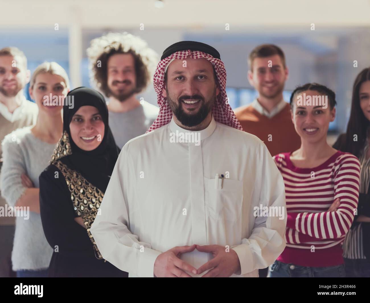 Portrait of multiracial diverse group of businesspeople team standing behind older Arab team leader Stock Photo