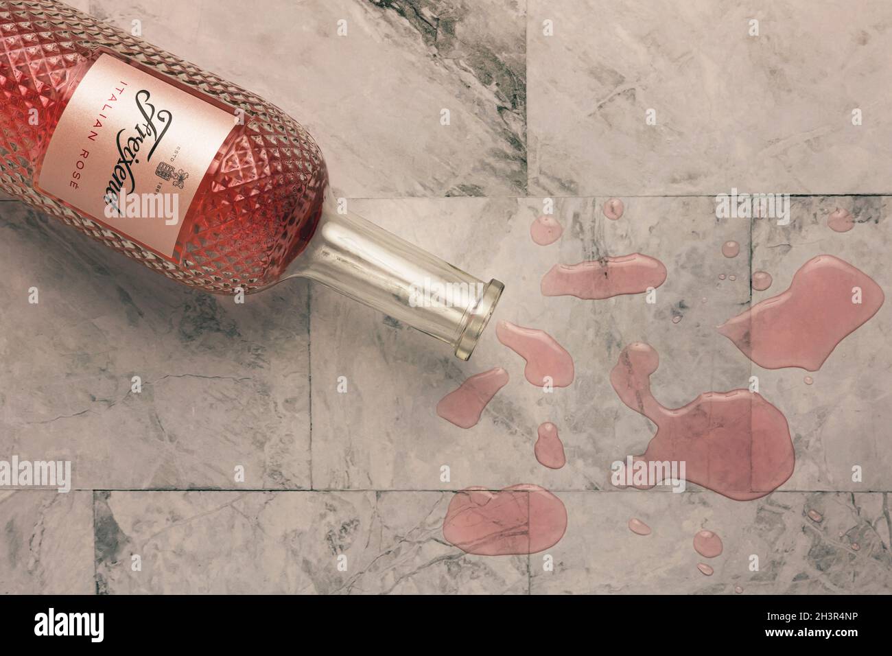 Accident happens. Spilled rose wine on the grey marble floor or kitchen worktop, top view, flatlay. Stock Photo