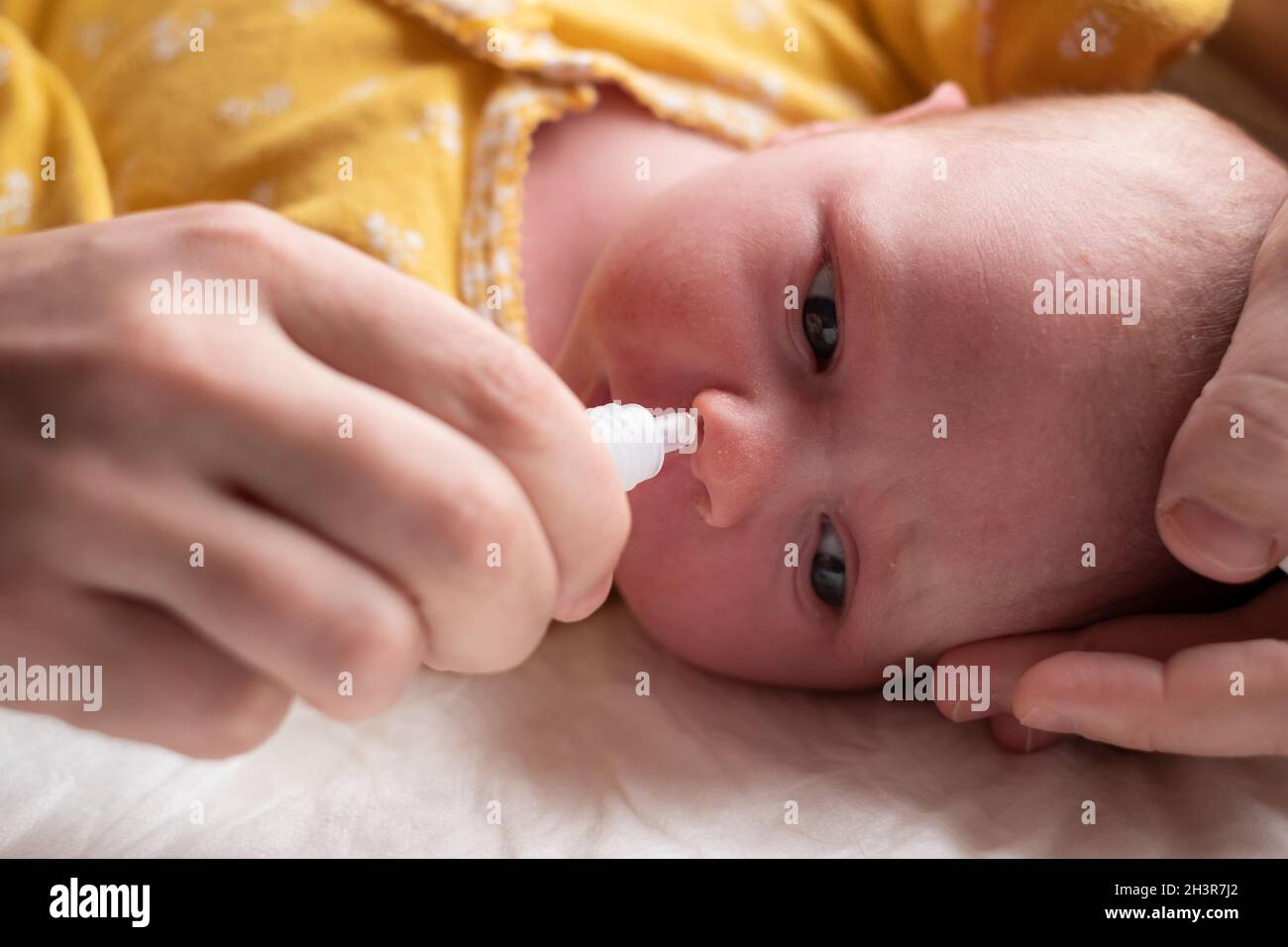 Mom puts drops in the nose of the child Stock Photo