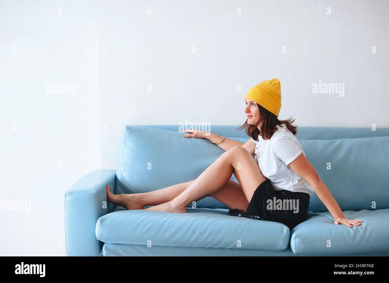 Stylish woman sitting on sofa Stock Photo
