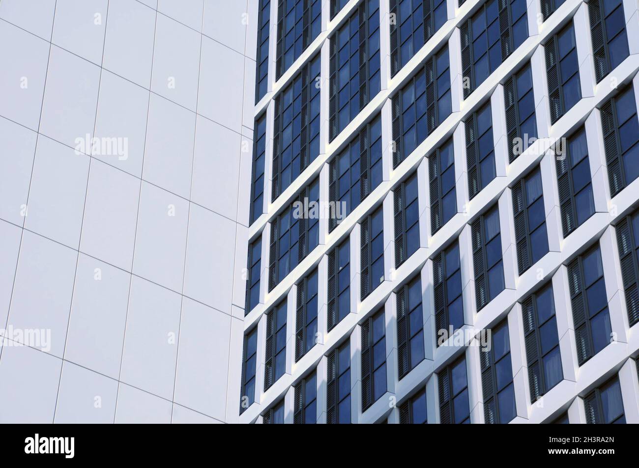 Close up detail of tall high rose modern apartment buildings with white cladding and dark windows Stock Photo