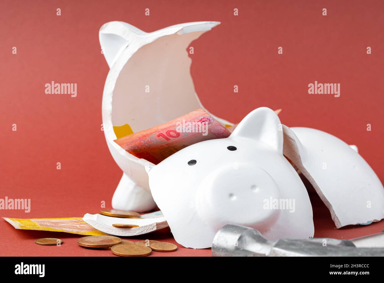 Broken piggy bank with ukrainian money notes and coins. Decline in