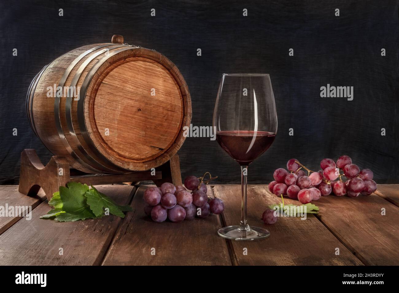 A glass of red wine with a wine barrel, grapes, and vine leaves Stock ...
