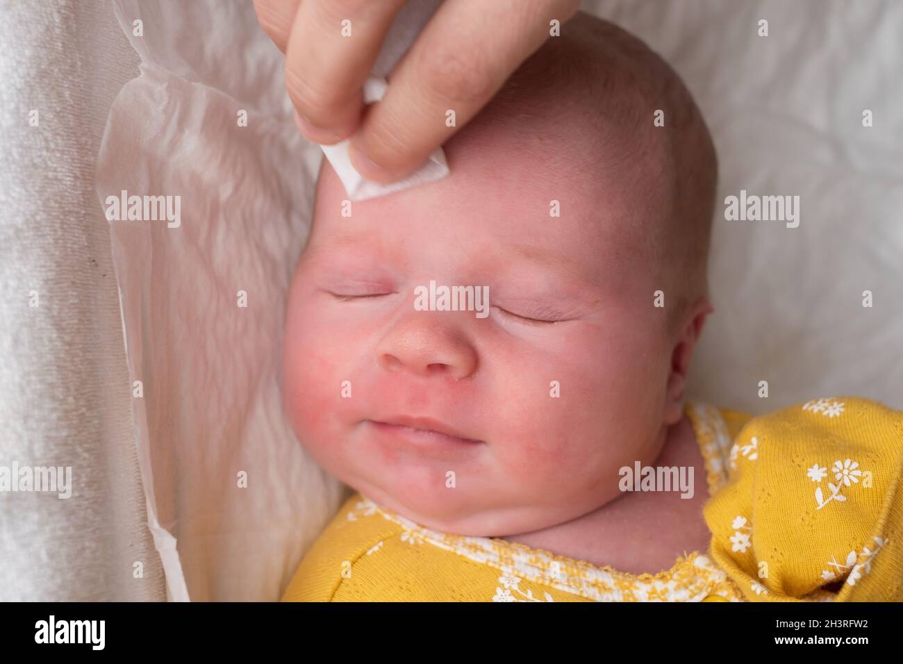 Cleaning baby's face on the morning. Hygiene procedures for the baby