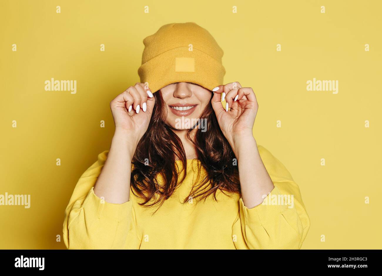 Cheerful woman in yellow outfit and hat Stock Photo - Alamy