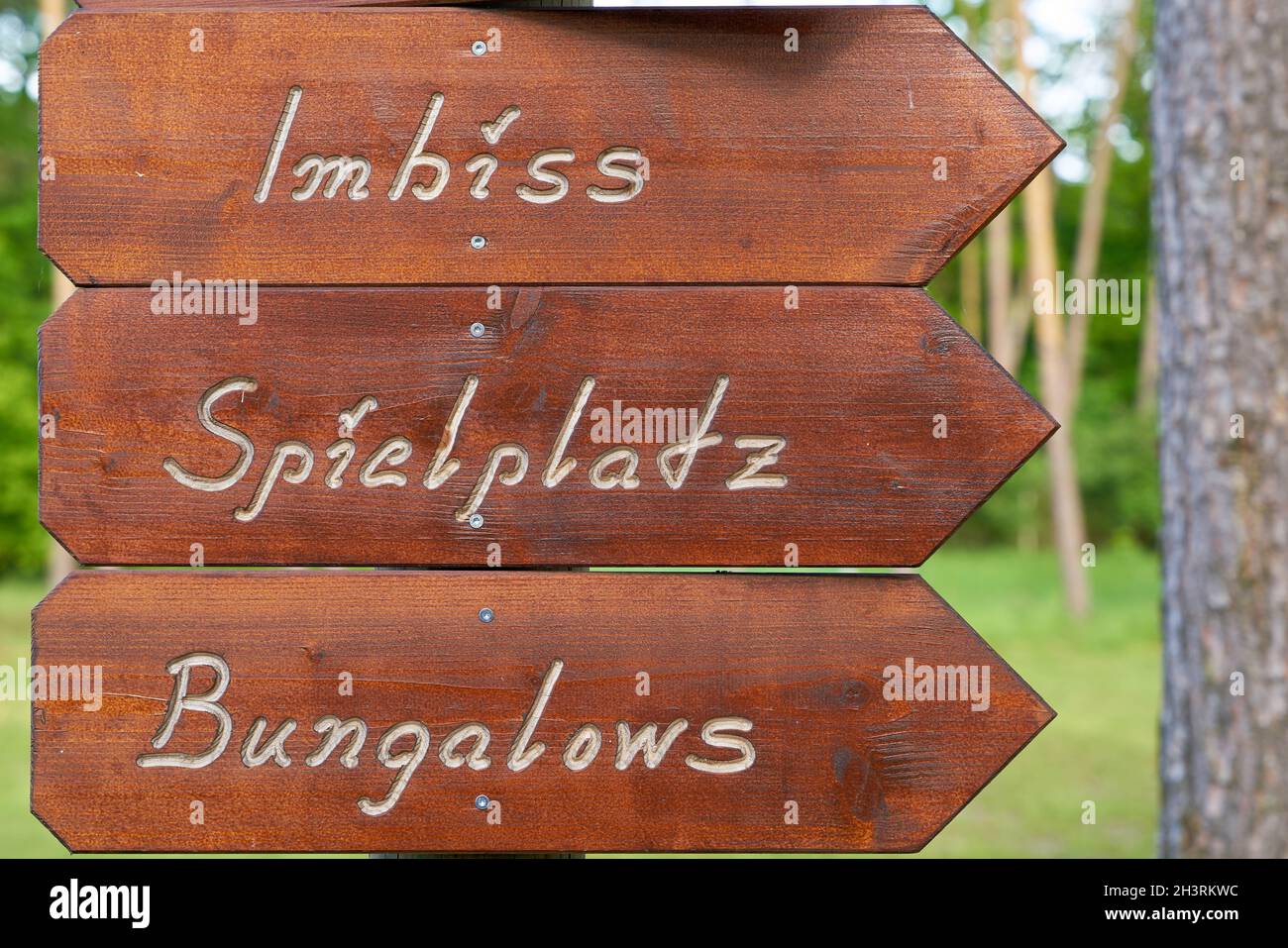 Signpost on a campsite in Germany with the inscription snack bar, playground, bungalows Stock Photo