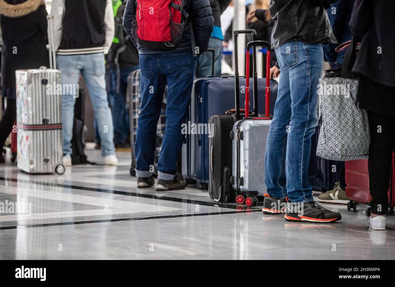 Stuttgart, Germany. 30th Oct, 2021. Passengers stand with their luggage at check-in counters at Stuttgart Airport at the start of the autumn holidays in Baden-Württemberg. Airports are a little busier again, but they are still a long way from their pre-Corona load factors. Credit: Christoph Schmidt/dpa/Alamy Live News Stock Photo