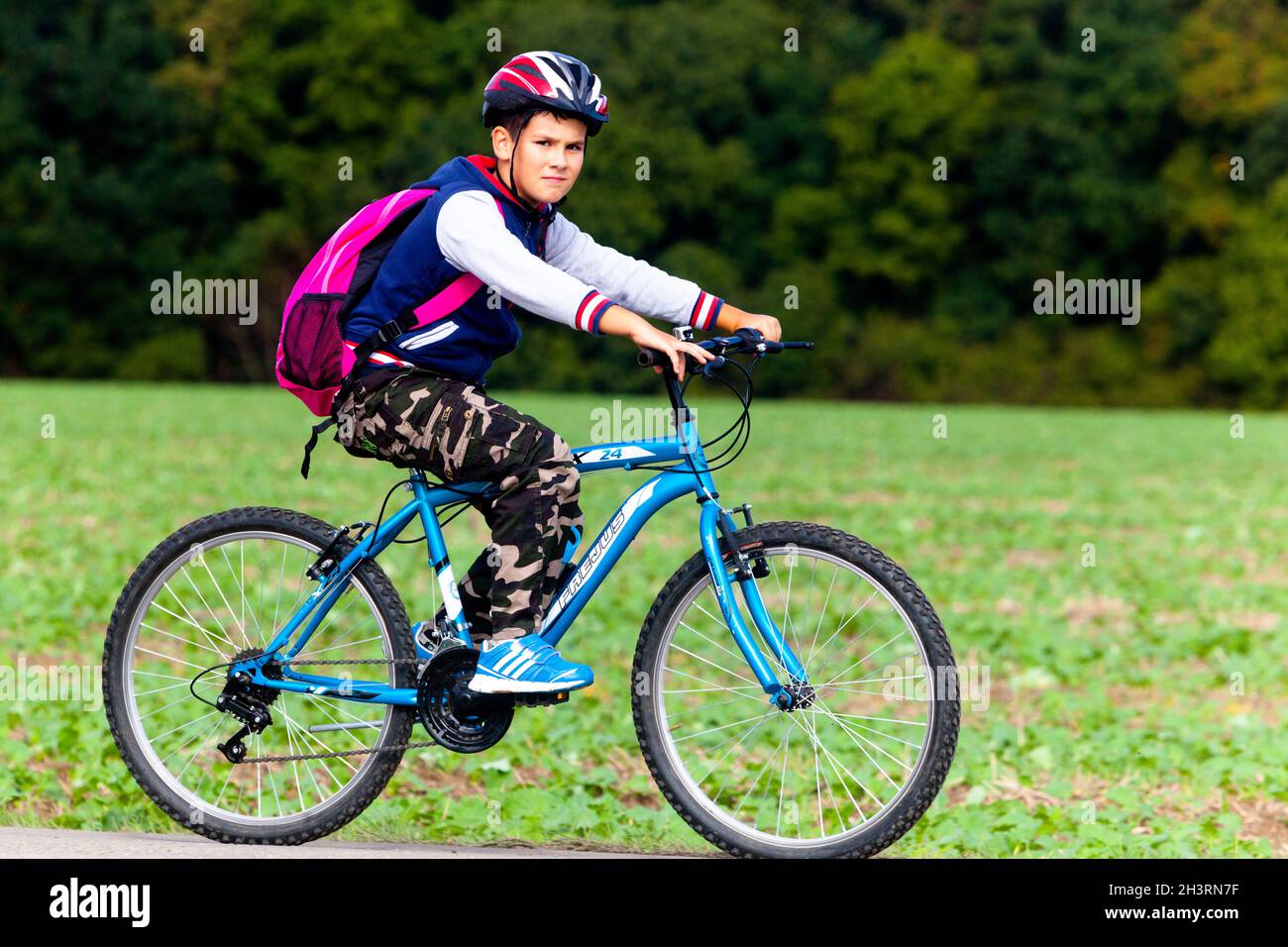 Child ride bike helmet backpack Stock Photo