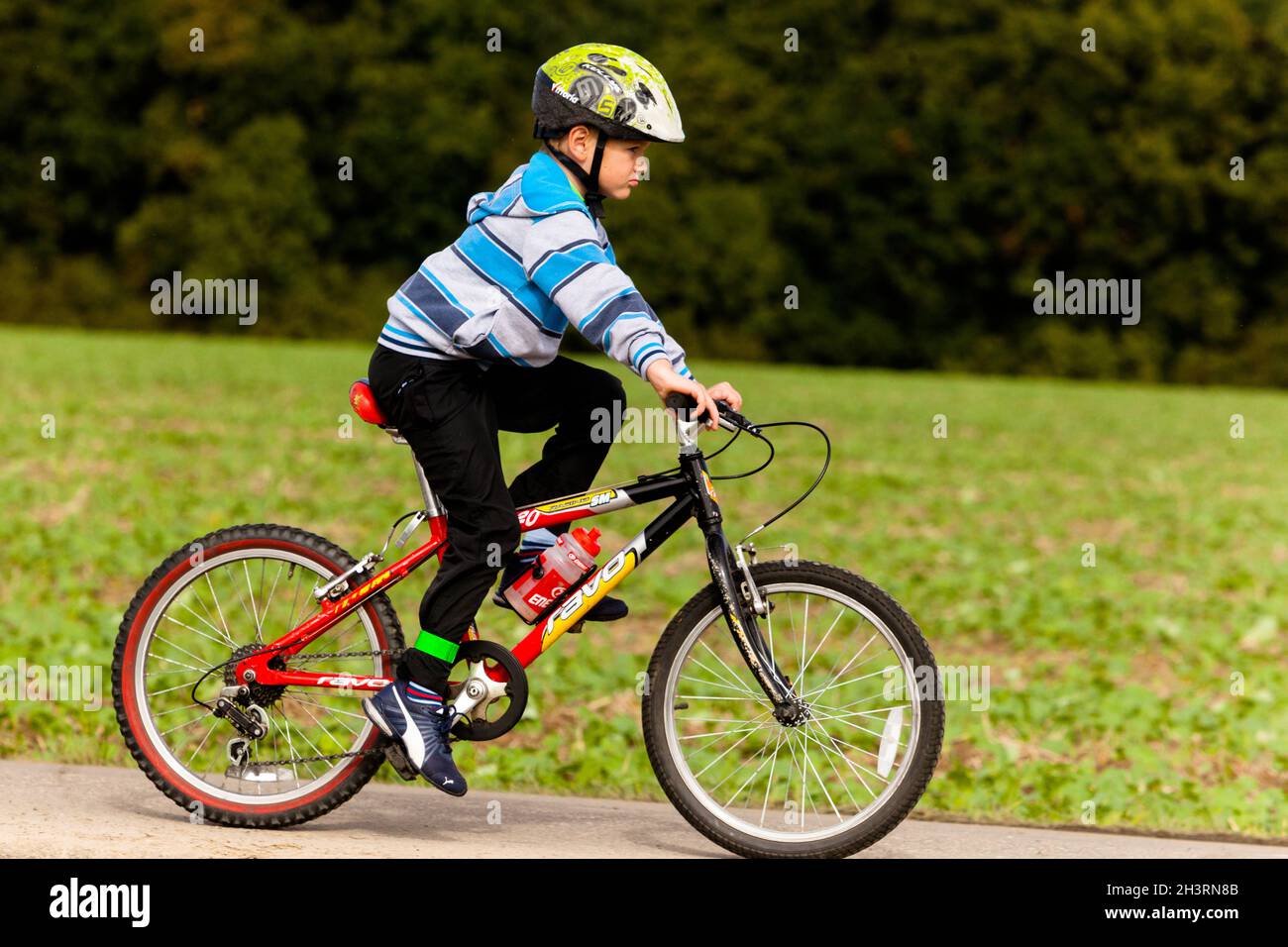 Child biker with helmet, boy ride bicycle Stock Photo