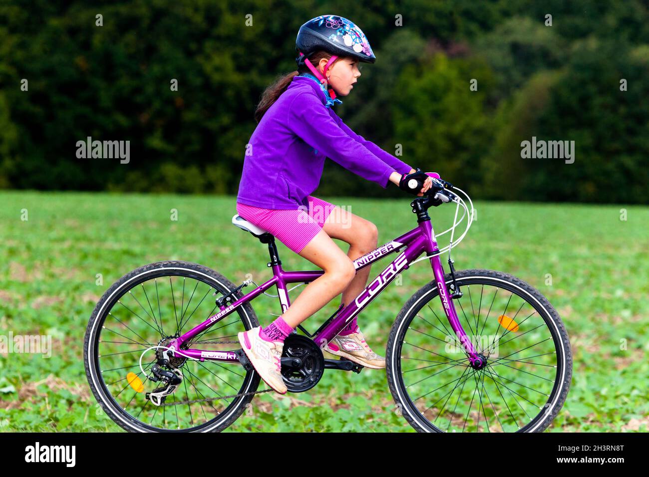 Girl ride bike helmet, child side view Stock Photo