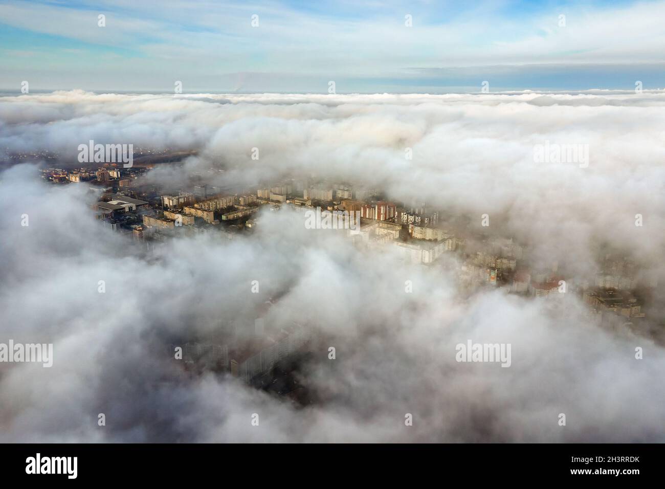 Top aerial view of fluffy white clouds over modern city with high rise ...