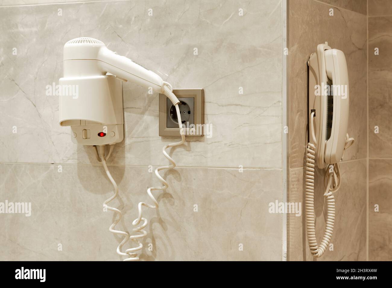 Hairdryer, electrical outlet and telephone on a bathroom wall Stock Photo Alamy