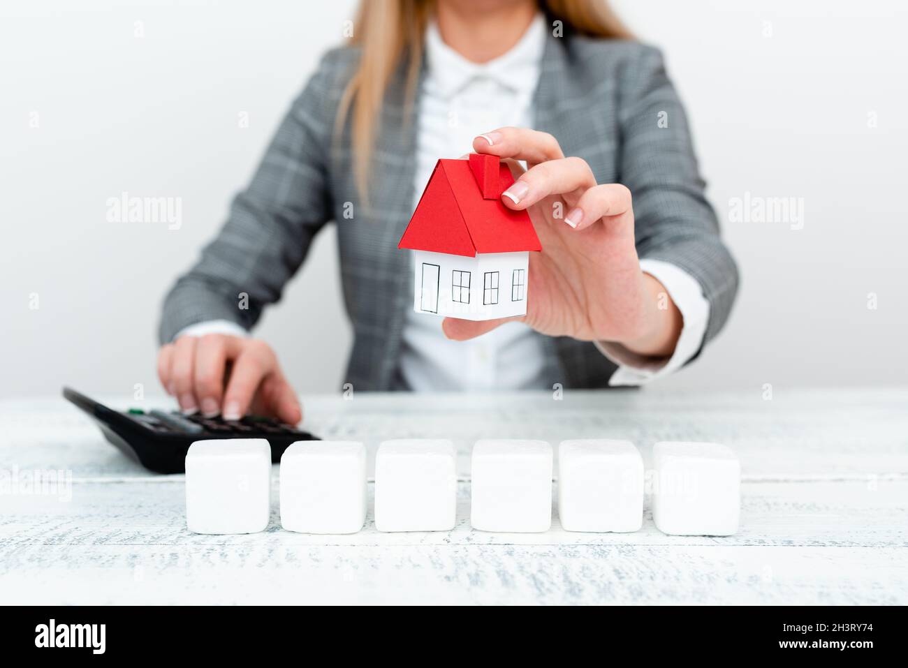 A Lady Holding Home In Business Outfit Presenting Possible Calculations For Owning Real Estate. Signing New Contract Orinsurance Stock Photo