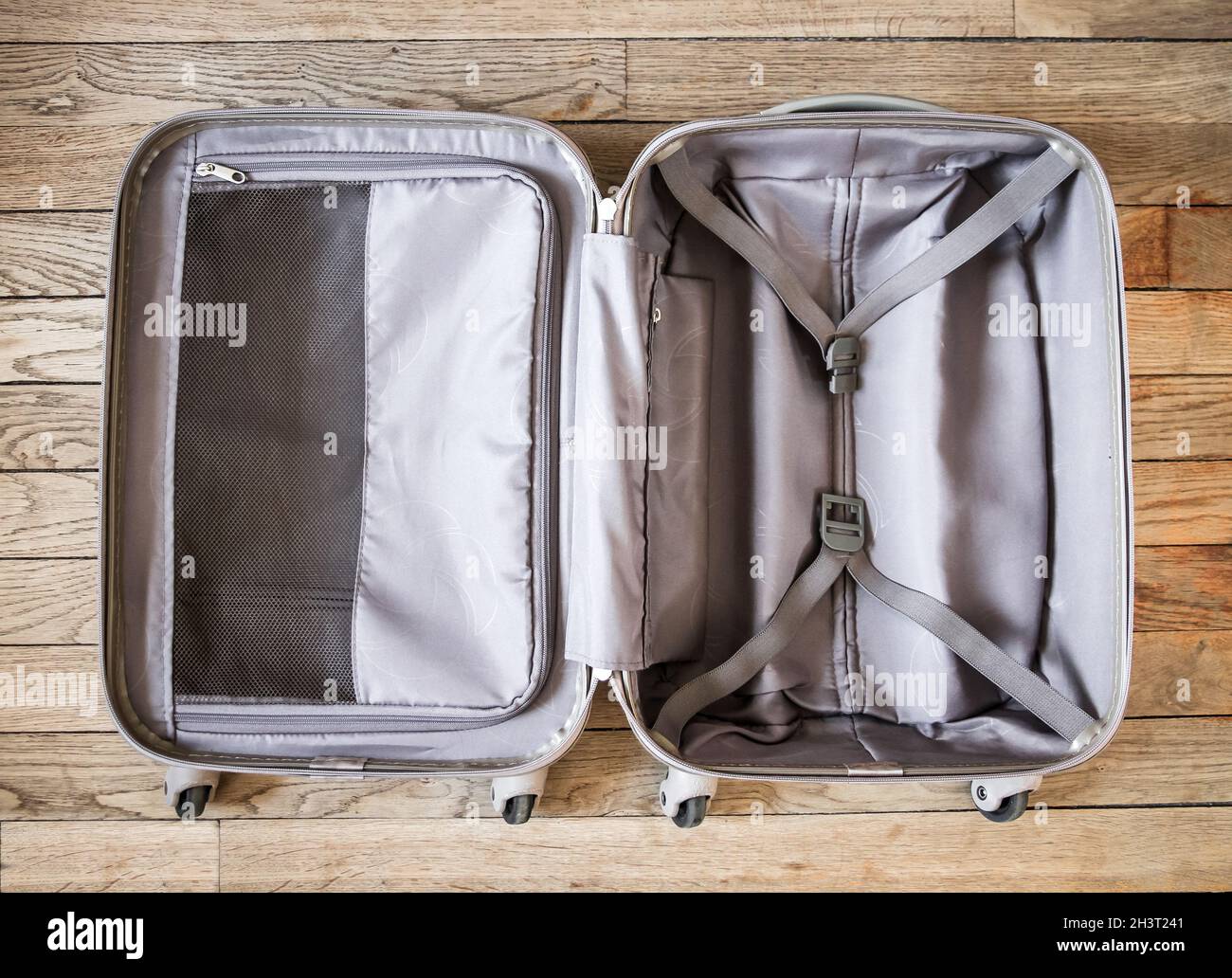 Open suitcase isolated on old wooden background Stock Photo