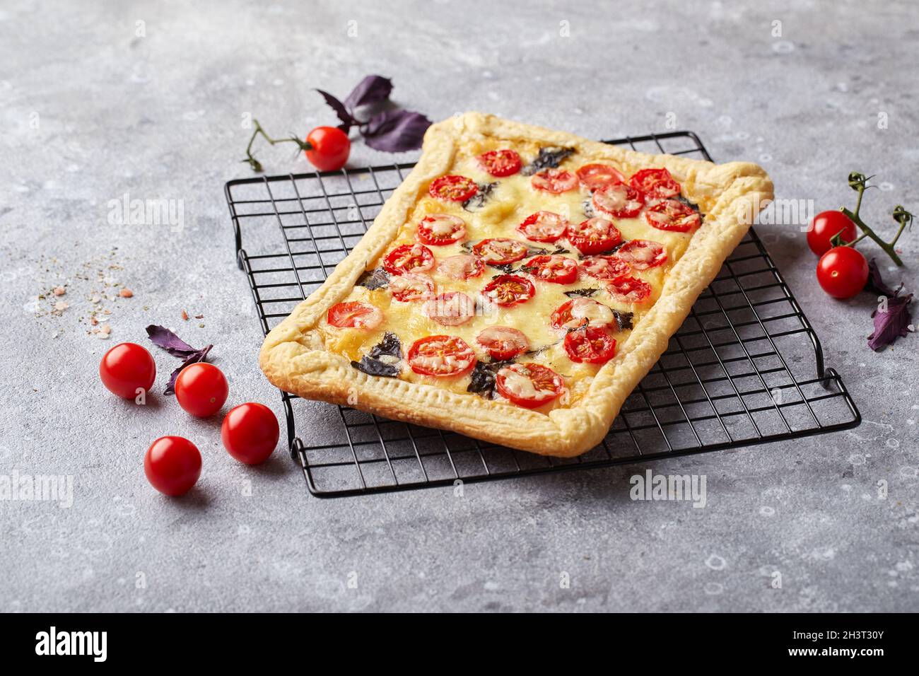 Puff pastry tart with cherry tomatoes, mozzarella and purple basil