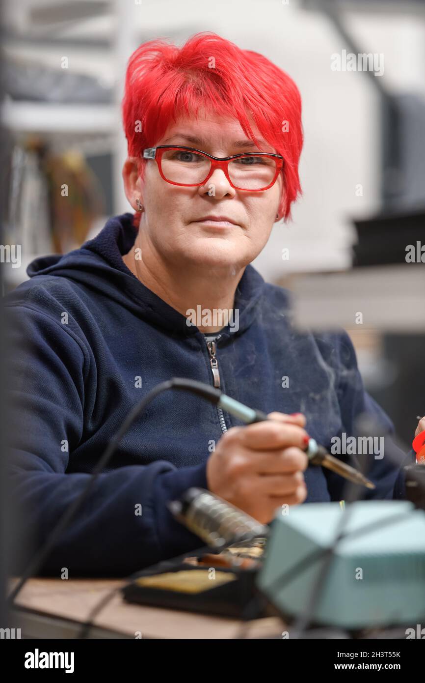 Industrial worker woman soldering cables of manufacturing equipment in a factory Stock Photo Alamy