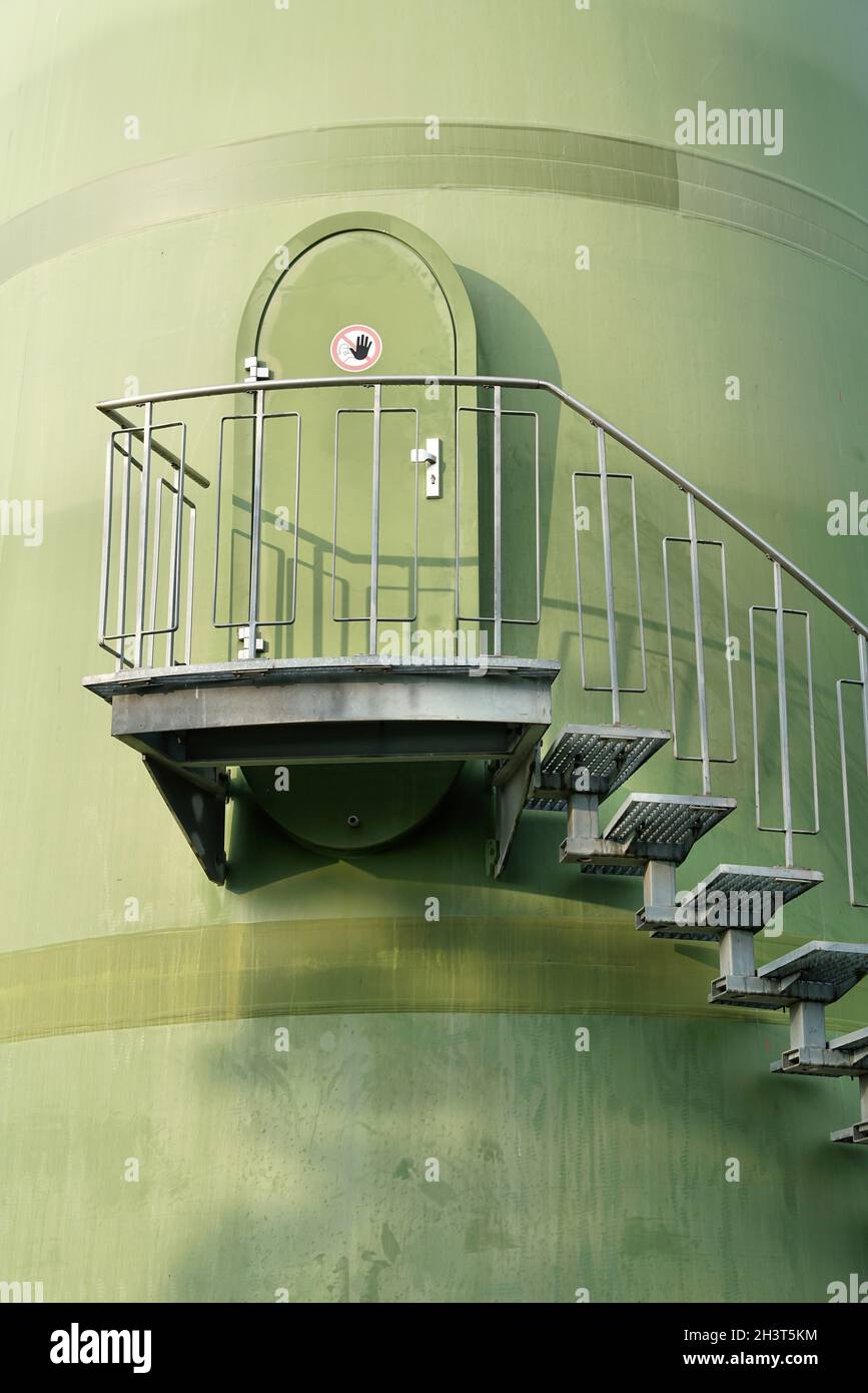 Stairs to a door on the tower of a wind turbine in an industrial area in Magdeburg in Germany Stock Photo