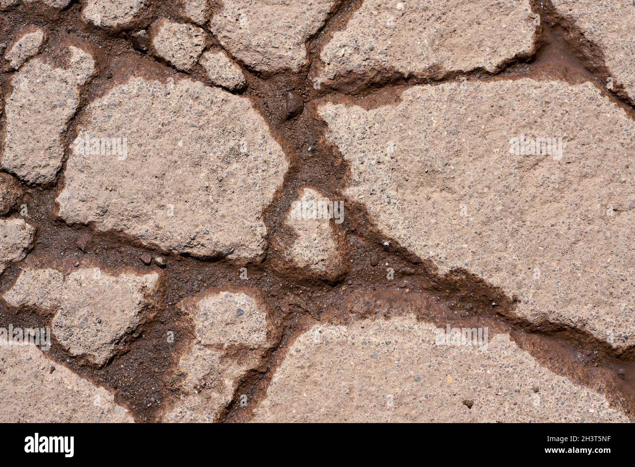 Cracks in the surface of the pavement of a weathered road Stock Photo