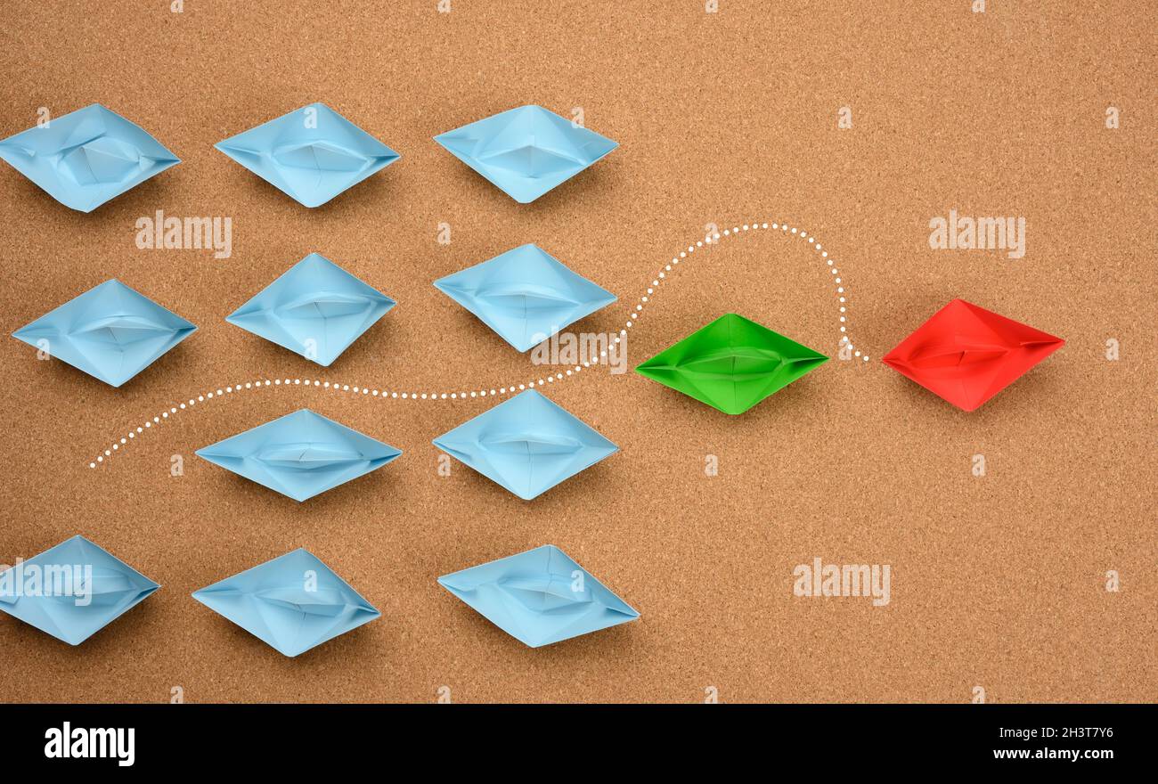 Group of blue boats and one red one, which rushed forward. The concept of achieving goals by unique talented people Stock Photo