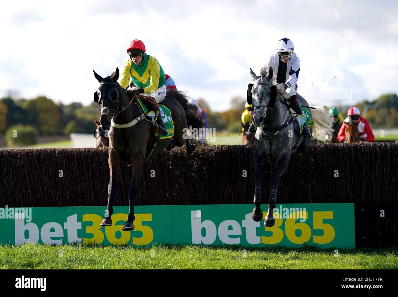 Sizing At Midnight ridden by jockey Brendan Powell (left) and Road Warrior ridden by jockey Nathan Moscrop clear a hurdle whilst competing in the bet365 Handicap Chase at Wetherby racecourse. Picture date: Saturday October 30, 2021. Stock Photo