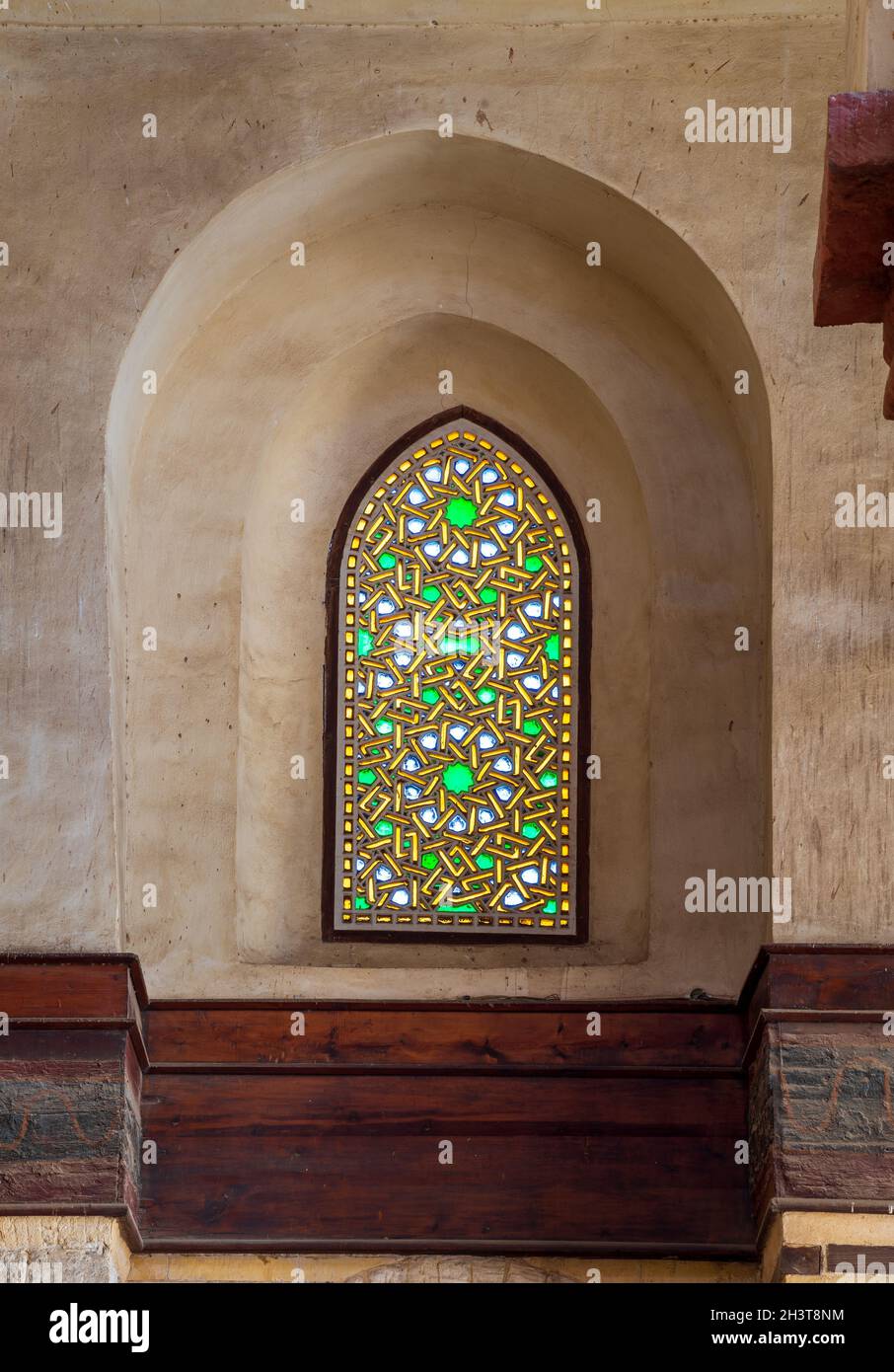 Perforated stucco window decorated with colorful stain glass with geometrical circular patterns and floral patterns, located at Mamluk era public historical Qalawun complex, Moez Street, Cairo, Egypt Stock Photo