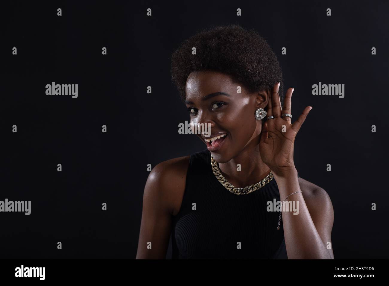 African American woman paying attention listening and holds hand on ear. Rumors, secrets and new information concept. Stock Photo