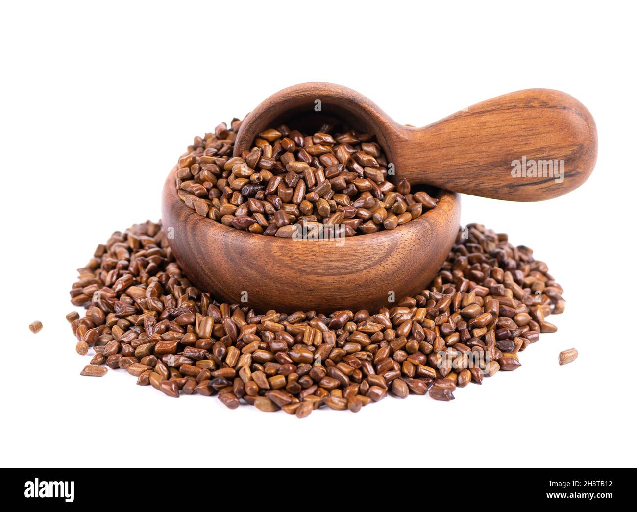 Cassia tora beans in wooden bowl and spoon, isolated on white background. Sicklepod or Senna obtusifolia. Clipping path. Stock Photo