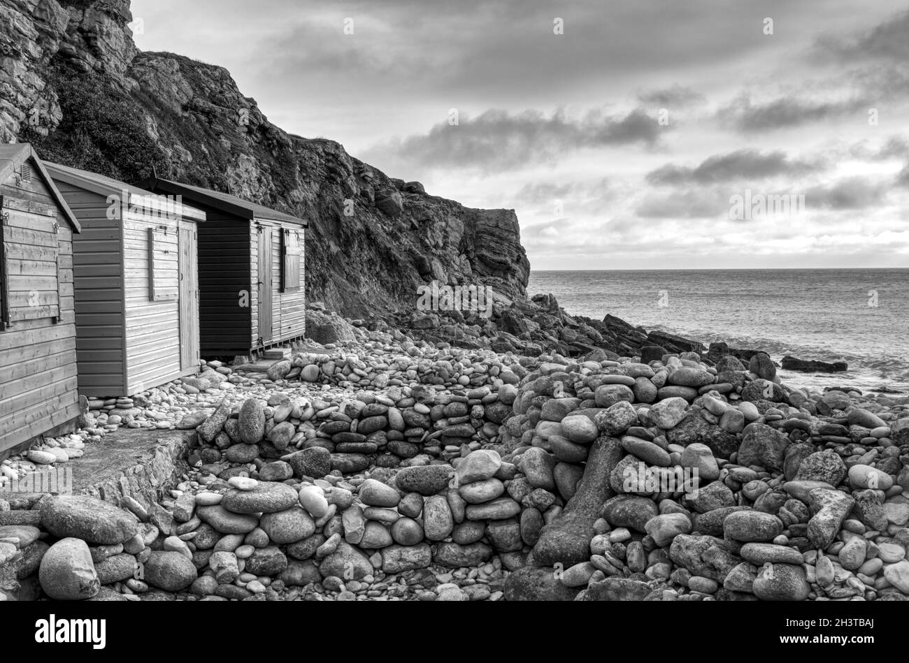 Grayscale shot of wooden cabins on the rocky shore of a sea Stock Photo ...