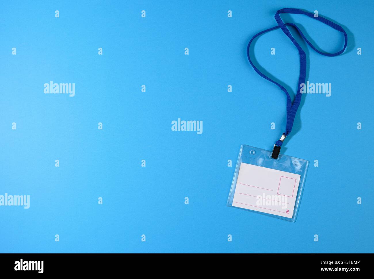Transparent plastic badge on a blue lanyard on a blue background Stock Photo