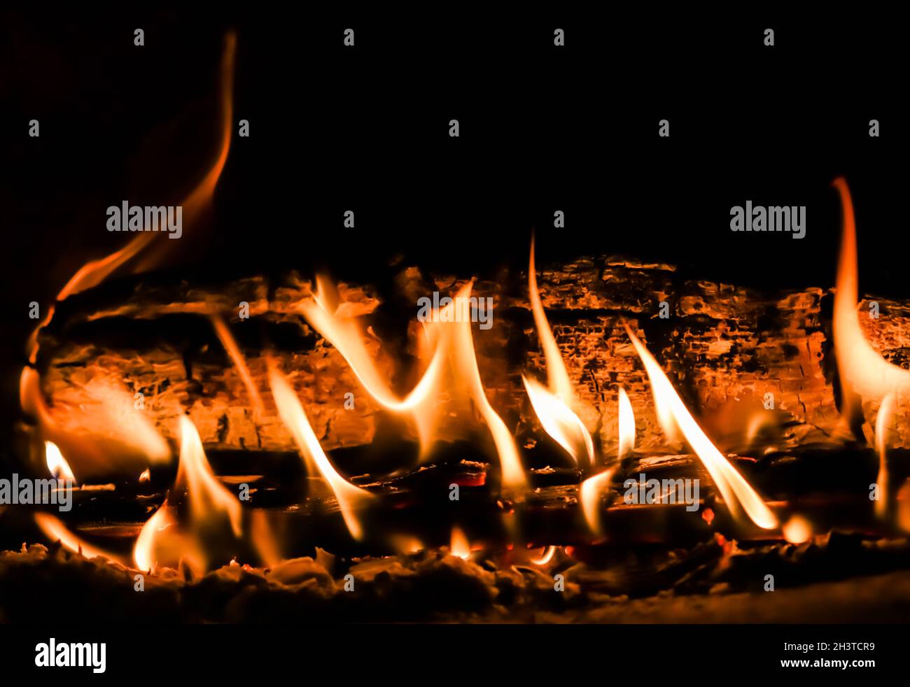 Flames of fire and hot coals of burned wood in the fireplace Stock