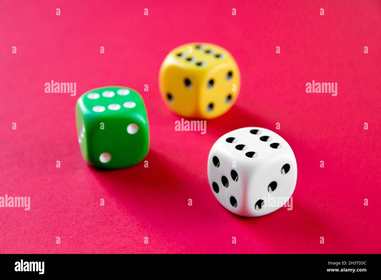 Three colorful dices isolated on pink background Stock Photo
