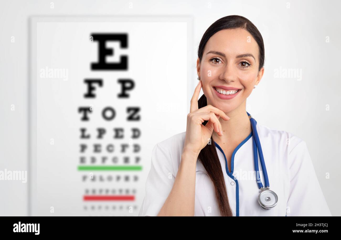 Eye doctor, oculist in clinic. Snellen chart in background Stock Photo