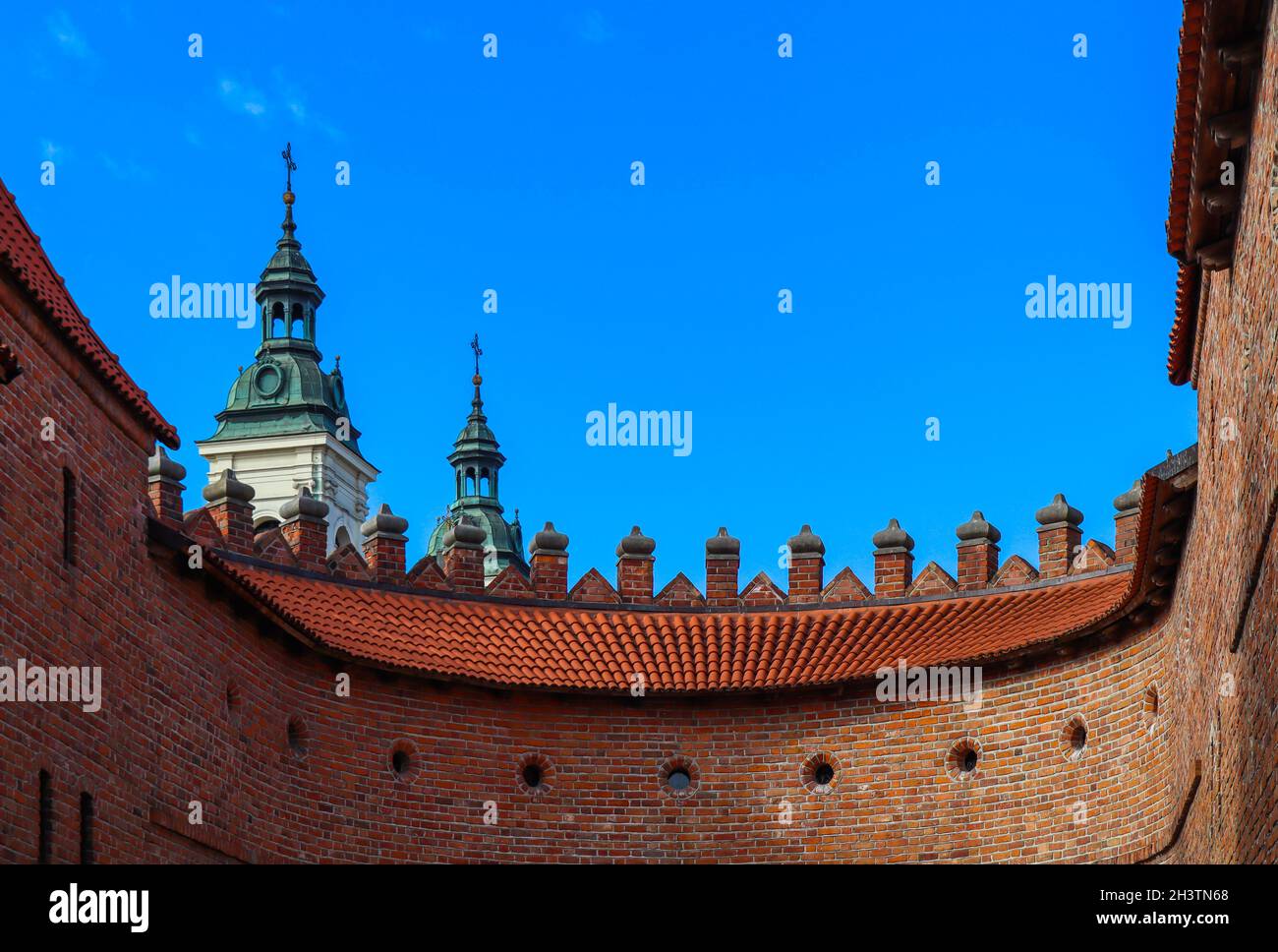 Two towers with spiers and red brick walls of Warsaw Barbican, Poland Stock Photo
