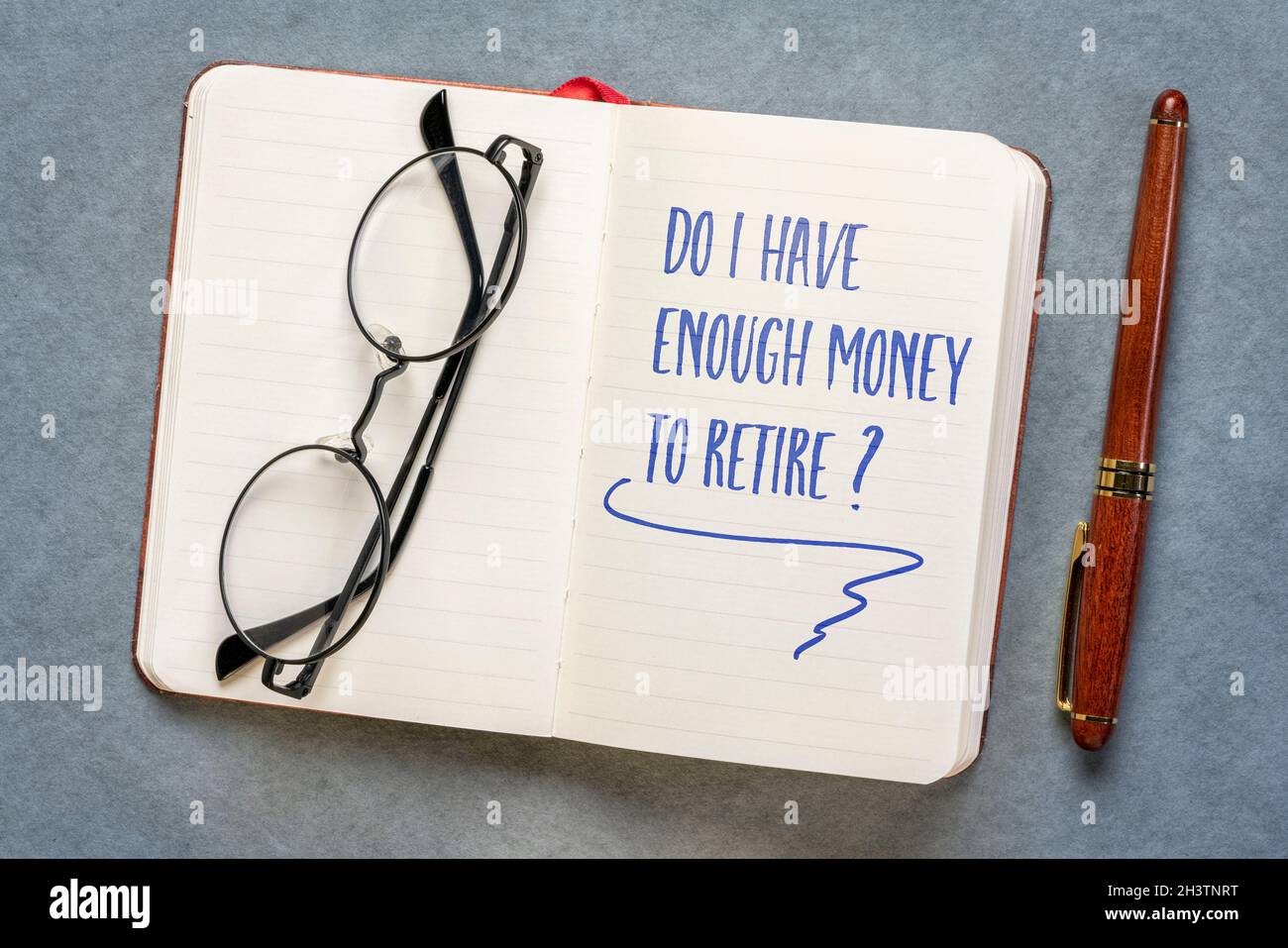 Do I have enough to retire? Handwriting in a notebook or journal. Finance and retirement planning concept. Stock Photo