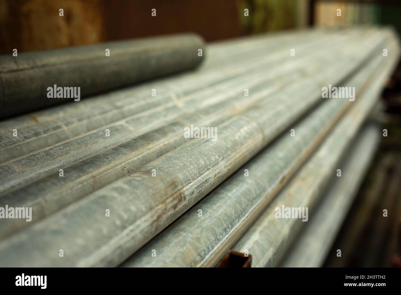 Steel pipes lie in a pile. Material in stock. Industry in detail. Tubes in the workshop. Stock Photo