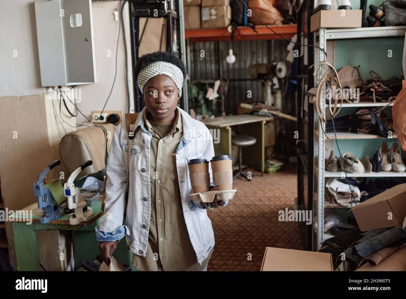 African young woman having a break at her work she carrying lunch box and coffee drinks Stock Photo