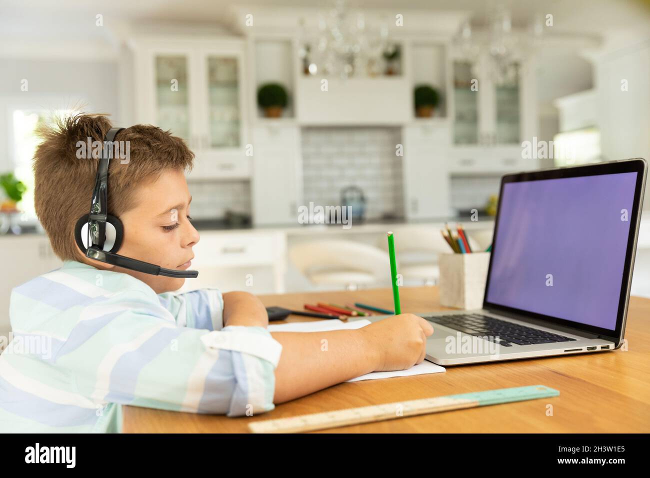 Caucasian boy using laptop with blank screen at home Stock Photo - Alamy