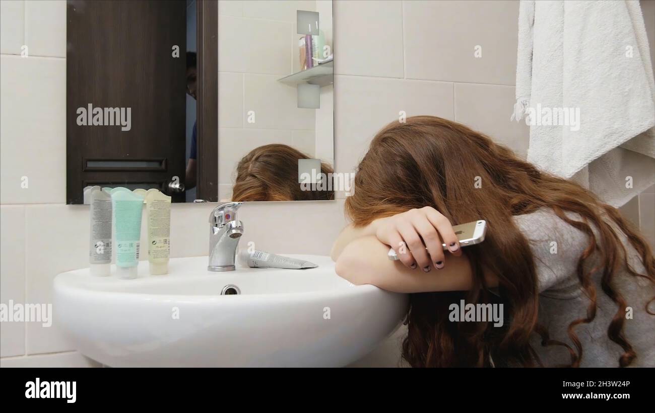 Woman crying in the bathroom after a quarrel with her husband, her husband calms Stock Photo Alamy