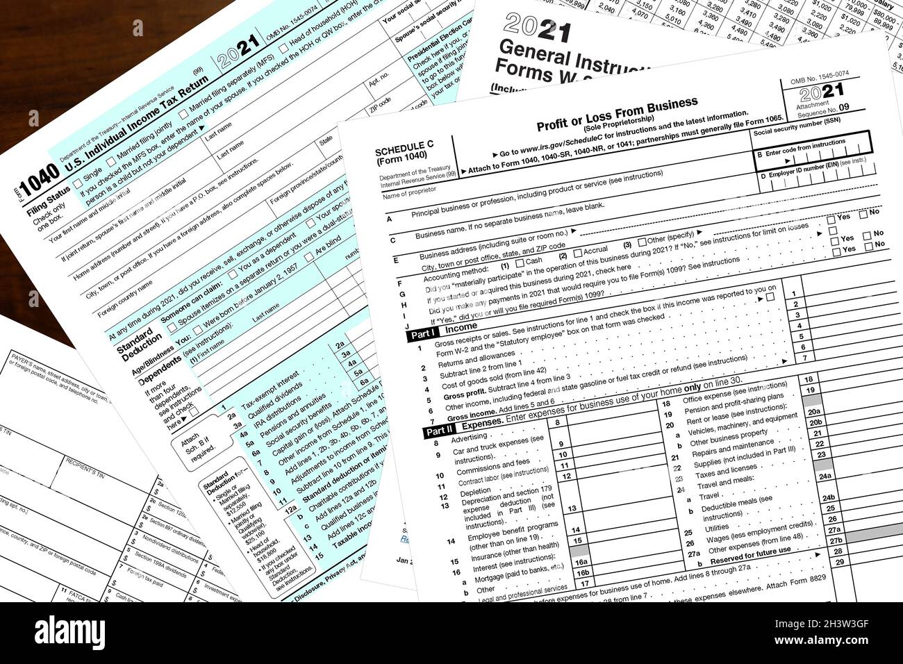 Various 2021 IRS tax forms on a wood desktop. Stock Photo