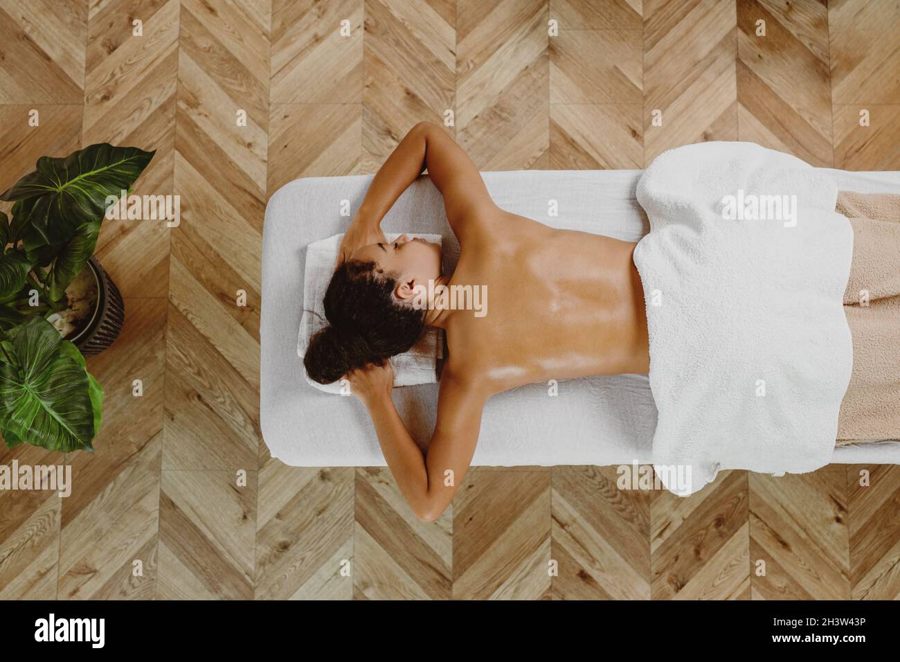 Top view of African American woman lying on massage table. Stock Photo